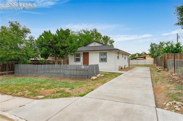 1205 Catalpa St, Pueblo, CO 81001 - bungalow-style home with concrete driveway, a fenced front yard, and stucco siding