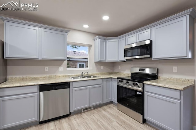 1205 Catalpa St, Pueblo, CO 81001 - kitchen featuring appliances with stainless steel finishes, a sink, light wood-style flooring, light countertops, and recessed lighting