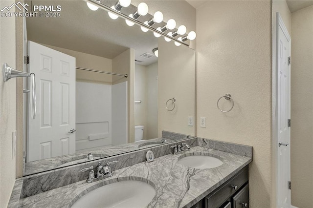 12213 Crystal Downs Rd, Peyton, CO 80831 - full bathroom featuring double vanity, toilet, a shower, and a textured wall