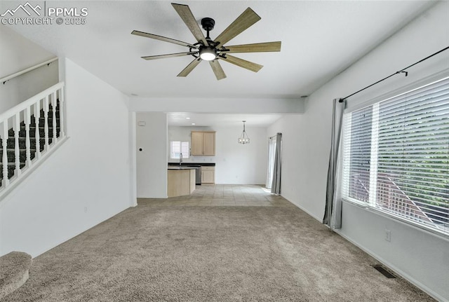 12213 Crystal Downs Rd, Peyton, CO 80831 - unfurnished living room with light carpet, a ceiling fan, healthy amount of natural light, and stairs