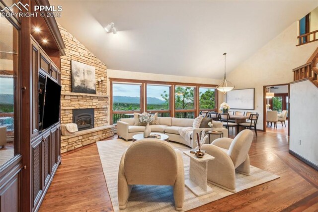 170 Salisbury Ct, Colorado Springs, CO 80906 - living room featuring high vaulted ceiling, a fireplace, light wood-style floors, and baseboards