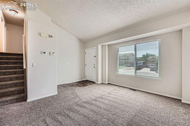 869 Marshall Dr, Fountain, CO 80817 - carpeted spare room featuring a textured ceiling, stairs, lofted ceiling, and baseboards