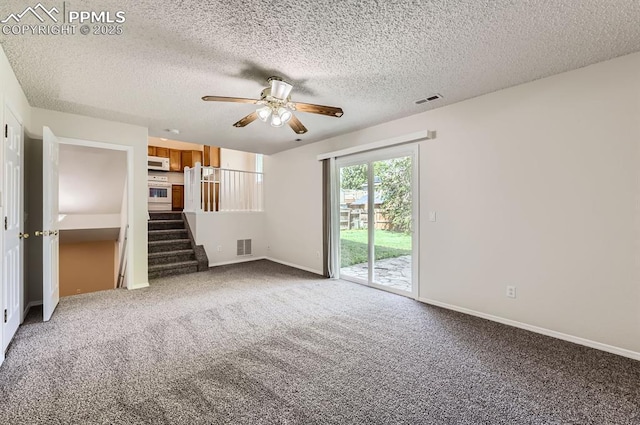 869 Marshall Dr, Fountain, CO 80817 - unfurnished living room with a ceiling fan, carpet, stairs, baseboards, and a textured ceiling