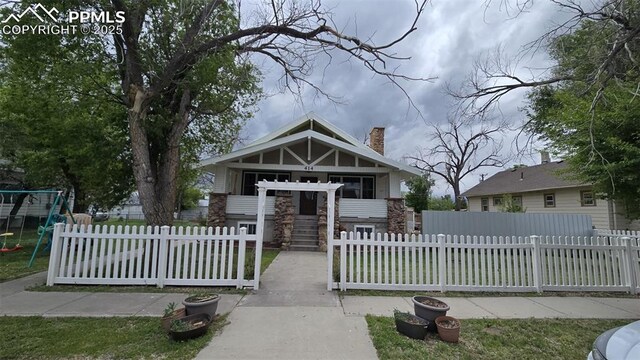 414 7th St, Hugo, CO 80821 - view of front of house with a chimney, a playground, and a fenced front yard