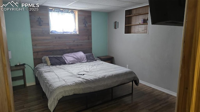 414 7th St, Hugo, CO 80821 - bedroom with wood walls, wood finished floors, a paneled ceiling, and baseboards