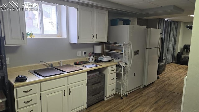 414 7th St, Hugo, CO 80821 - kitchen with light countertops, freestanding refrigerator, dark wood-type flooring, and white cabinetry