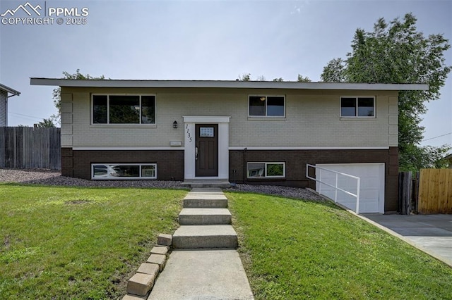 1135 Server Dr, Colorado Springs, CO 80910 - raised ranch featuring brick siding, an attached garage, and driveway