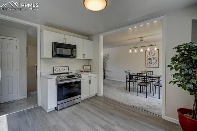 1135 Server Dr, Colorado Springs, CO 80910 - kitchen featuring black microwave, stainless steel electric range oven, white cabinetry, and light countertops