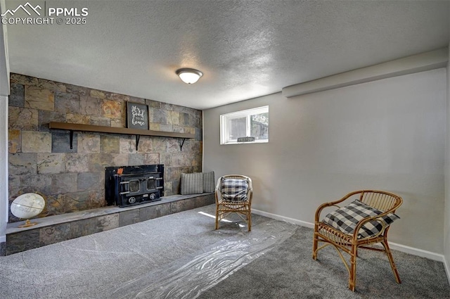 1135 Server Dr, Colorado Springs, CO 80910 - sitting room with a wood stove, a textured ceiling, baseboards, and carpet