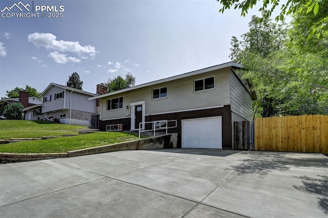 1135 Server Dr, Colorado Springs, CO 80910 - raised ranch with a garage, a chimney, concrete driveway, and brick siding