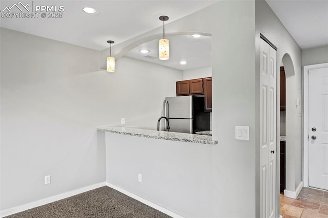 128 W Rockrimmon Blvd Unit 105, Colorado Springs, CO 80919 - kitchen featuring freestanding refrigerator, arched walkways, recessed lighting, decorative light fixtures, and a peninsula