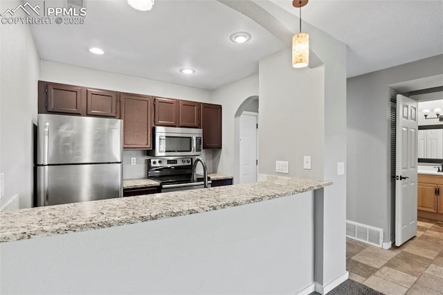 128 W Rockrimmon Blvd Unit 105, Colorado Springs, CO 80919 - kitchen featuring stainless steel appliances, arched walkways, decorative light fixtures, a peninsula, and light stone countertops