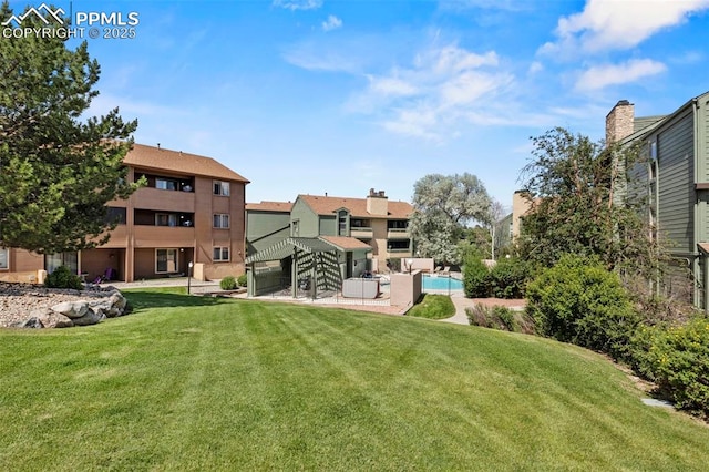 128 W Rockrimmon Blvd Unit 105, Colorado Springs, CO 80919 - view of grassy yard with an outdoor pool and a patio area