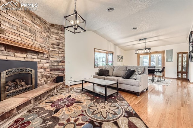 3660 E Wade Ln, Colorado Springs, CO 80917 - living area featuring a textured ceiling, electric panel, wood finished floors, healthy amount of natural light, and vaulted ceiling
