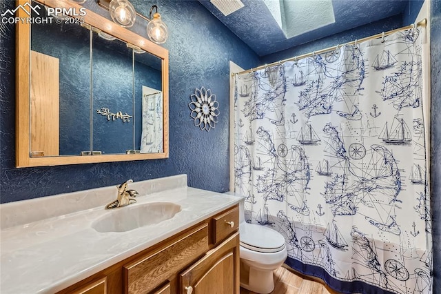 3660 E Wade Ln, Colorado Springs, CO 80917 - full bathroom with a textured wall, toilet, vanity, wood finished floors, and a shower with shower curtain