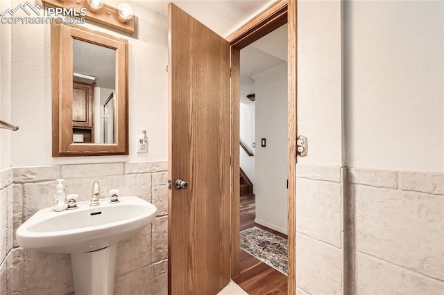 3660 E Wade Ln, Colorado Springs, CO 80917 - bathroom with wood finished floors, tile walls, and a wainscoted wall