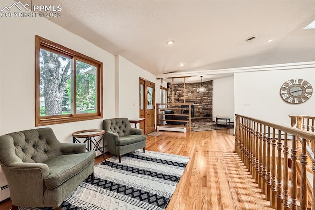3660 E Wade Ln, Colorado Springs, CO 80917 - living room featuring a baseboard heating unit, wood finished floors, recessed lighting, and a brick fireplace