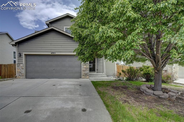 4959 Gami Way, Colorado Springs, CO 80911 - obstructed view of property featuring driveway, stone siding, and a garage