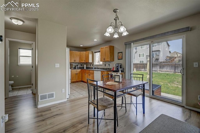 4959 Gami Way, Colorado Springs, CO 80911 - dining space featuring a chandelier, baseboards, and light wood-style flooring