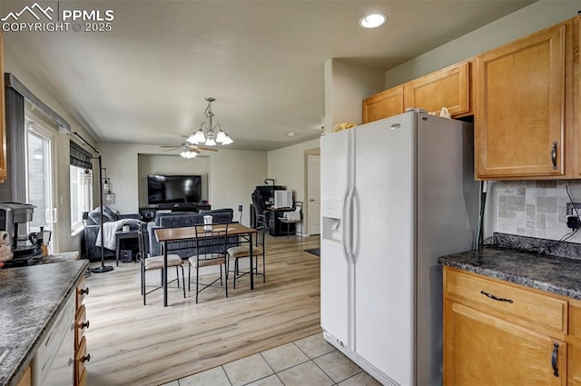 4959 Gami Way, Colorado Springs, CO 80911 - kitchen featuring white refrigerator with ice dispenser, dark countertops, recessed lighting, a chandelier, and backsplash