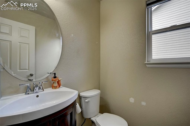 4959 Gami Way, Colorado Springs, CO 80911 - half bathroom featuring toilet, vanity, and a textured wall