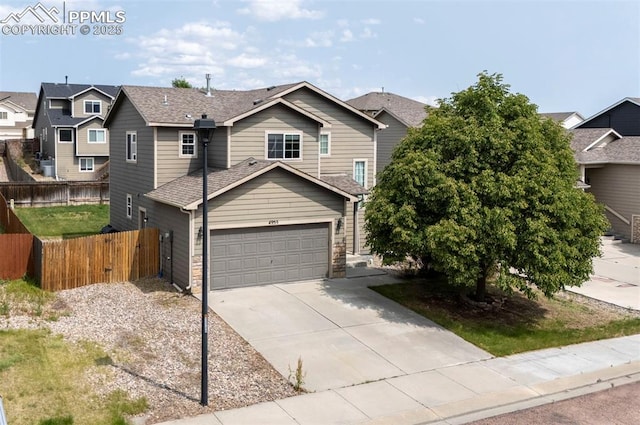 4959 Gami Way, Colorado Springs, CO 80911 - view of front of house featuring driveway, a garage, a residential view, roof with shingles, and stone siding