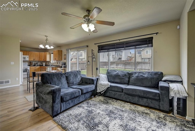 4959 Gami Way, Colorado Springs, CO 80911 - living area with a chandelier, light wood-type flooring, a ceiling fan, and baseboards