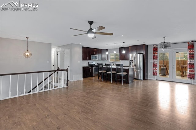 4623 Ranch Cir, Colorado Springs, CO 80918 - kitchen featuring appliances with stainless steel finishes, a breakfast bar, dark brown cabinets, and wood finished floors