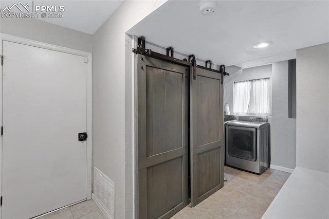 4623 Ranch Cir, Colorado Springs, CO 80918 - washroom with washer / clothes dryer, a barn door, and light tile patterned floors