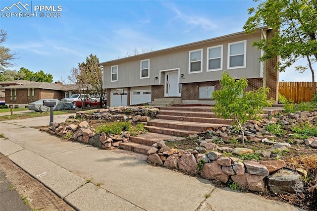 4623 Ranch Cir, Colorado Springs, CO 80918 - raised ranch with brick siding, a garage, driveway, and entry steps