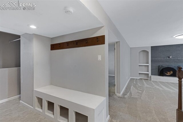 4623 Ranch Cir, Colorado Springs, CO 80918 - mudroom featuring built in shelves, a brick fireplace, baseboards, and carpet