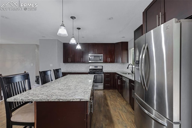 4623 Ranch Cir, Colorado Springs, CO 80918 - kitchen featuring stainless steel appliances, a sink, dark wood-style flooring, a breakfast bar, and a center island