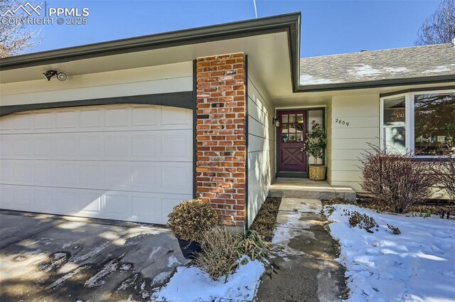 2809 Flintridge Dr, Colorado Springs, CO 80918 - snow covered property entrance featuring an attached garage