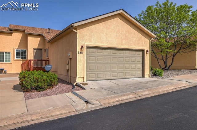 688 Bosque Vista Pt, Colorado Springs, CO 80916 - view of front facade featuring stucco siding, a garage, and driveway
