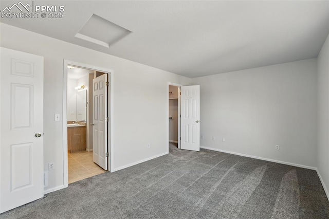 688 Bosque Vista Pt, Colorado Springs, CO 80916 - unfurnished bedroom with attic access, carpet floors, a spacious closet, a sink, and baseboards