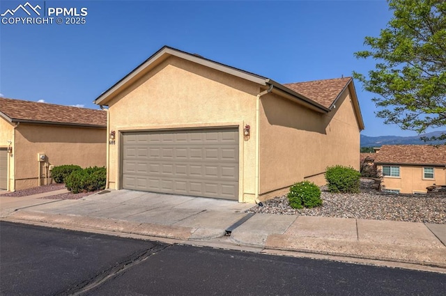 688 Bosque Vista Pt, Colorado Springs, CO 80916 - view of front of property featuring an attached garage, stucco siding, concrete driveway, and a mountain view