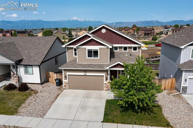 6078 Jorie Rd, Colorado Springs, CO 80927 - craftsman inspired home with board and batten siding, a mountain view, concrete driveway, and a residential view