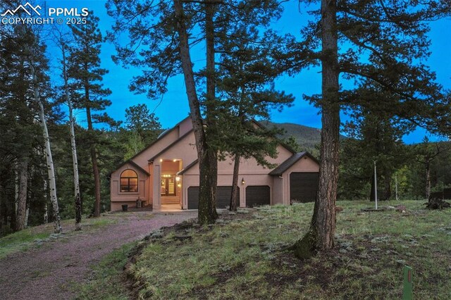 2100 N Elk Rdg, Divide, CO 80814 - view of side of home featuring stucco siding, an attached garage, and dirt driveway