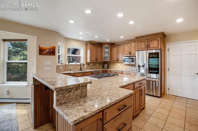 2100 N Elk Rdg, Divide, CO 80814 - kitchen with stainless steel appliances, a sink, a baseboard heating unit, light tile patterned flooring, and brown cabinetry