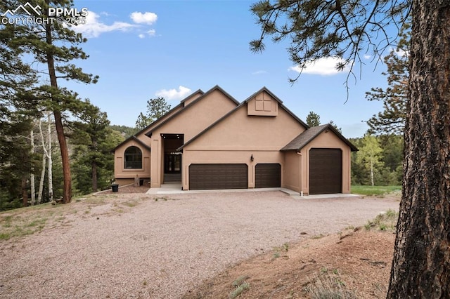2100 N Elk Rdg, Divide, CO 80814 - view of front of property with dirt driveway, stucco siding, and an attached garage