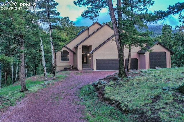 2100 N Elk Rdg, Divide, CO 80814 - view of front of home with stucco siding, gravel driveway, and a garage