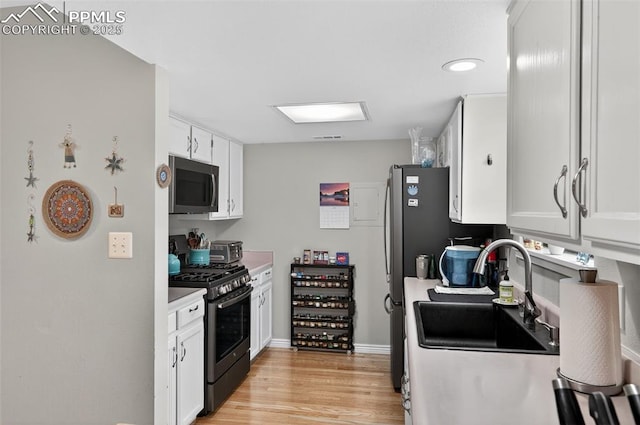 686 Echo Ln, Colorado Springs, CO 80904 - kitchen featuring stainless steel appliances, white cabinets, light countertops, and light wood-style floors