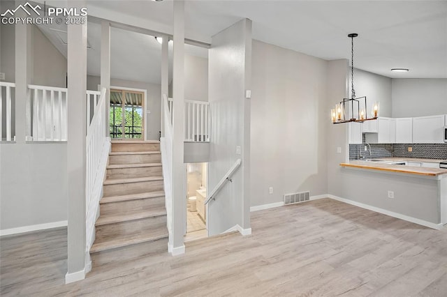 4408 Winding Cir, Colorado Springs, CO 80917 - stairs with a chandelier, wood finished floors, and lofted ceiling