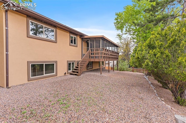 4408 Winding Cir, Colorado Springs, CO 80917 - rear view of house with a sunroom, stairs, and stucco siding