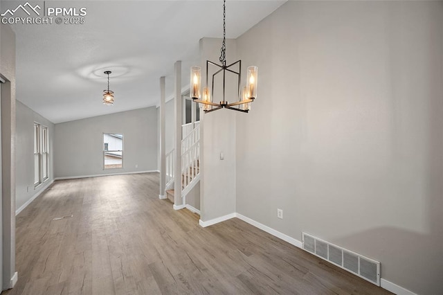 4408 Winding Cir, Colorado Springs, CO 80917 - unfurnished dining area with a chandelier, stairs, wood finished floors, and lofted ceiling
