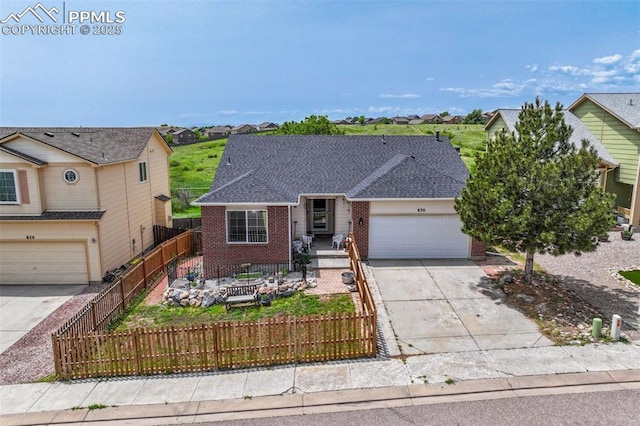 830 Winebrook Way, Fountain, CO 80817 - view of front of house with concrete driveway, brick siding, an attached garage, and a fenced front yard