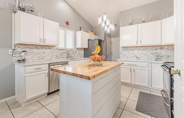 830 Winebrook Way, Fountain, CO 80817 - kitchen with appliances with stainless steel finishes, lofted ceiling, butcher block counters, a center island, and light tile patterned floors
