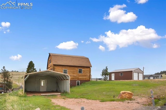 226 W El Paso Ave, Cripple Creek, CO 80813 - rear view of house featuring a detached carport, an outdoor structure, a garage, a yard, and driveway