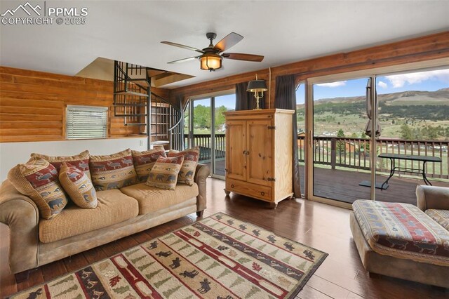 226 W El Paso Ave, Cripple Creek, CO 80813 - living room with a ceiling fan, wood walls, wood finished floors, and stairs