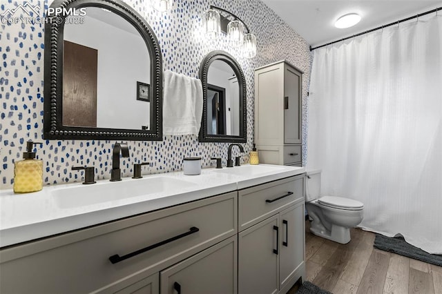 4303 W Eastcrest Cir, Colorado Springs, CO 80916 - full bath featuring wallpapered walls, wood finished floors, toilet, double vanity, and a shower with shower curtain